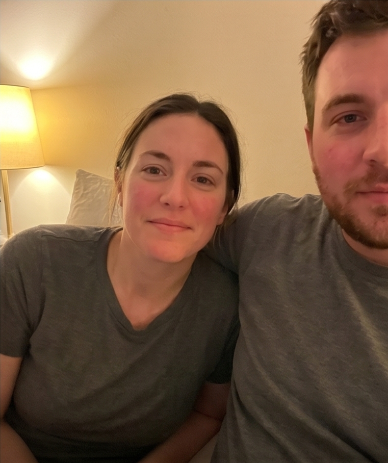 Two people after the four-minute experiment, relaxed and present, lit by a single bedside lamp